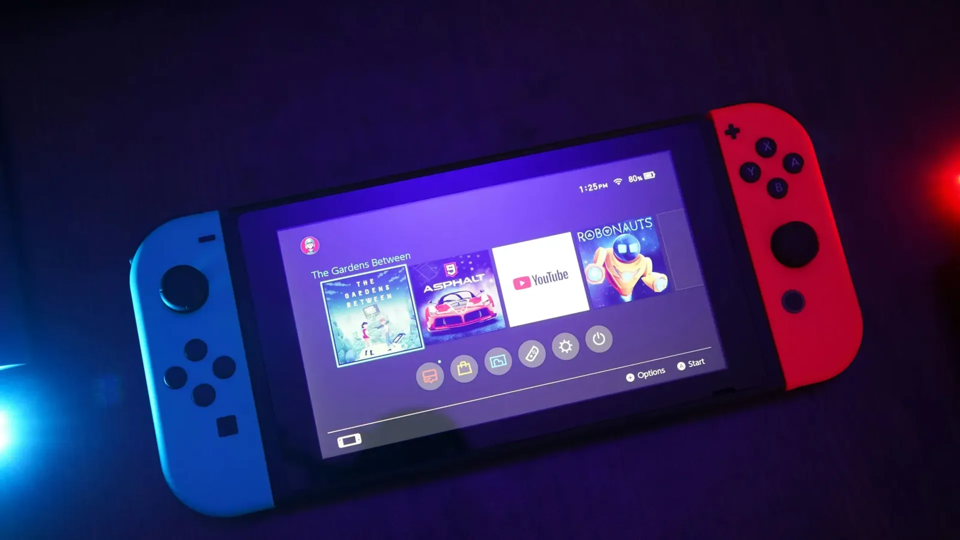 Nintendo Switch en modo portátil con Joy-Con neón azul y rojo en el menú